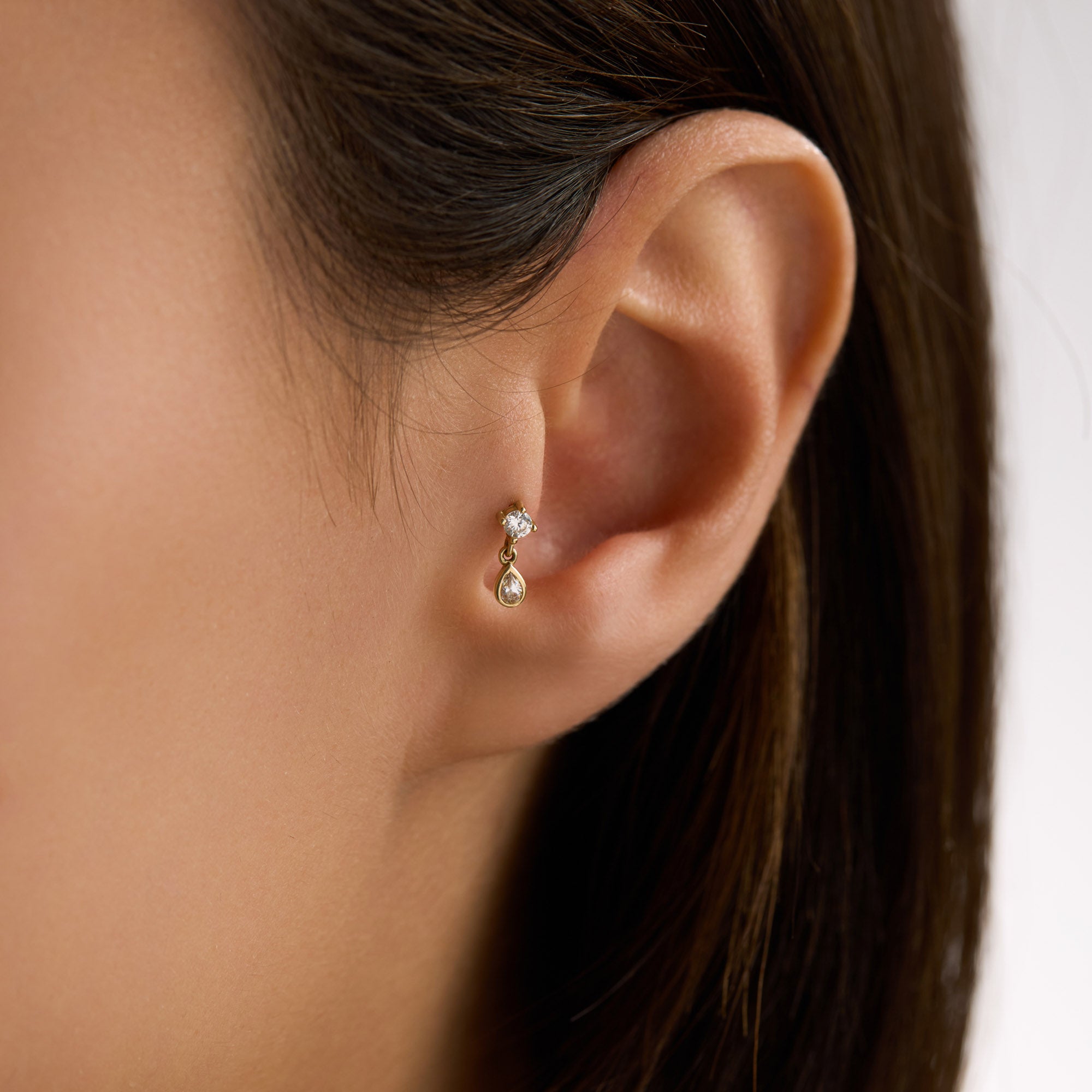 Close-up of woman's an ear tragus wearing a teardrop piercing