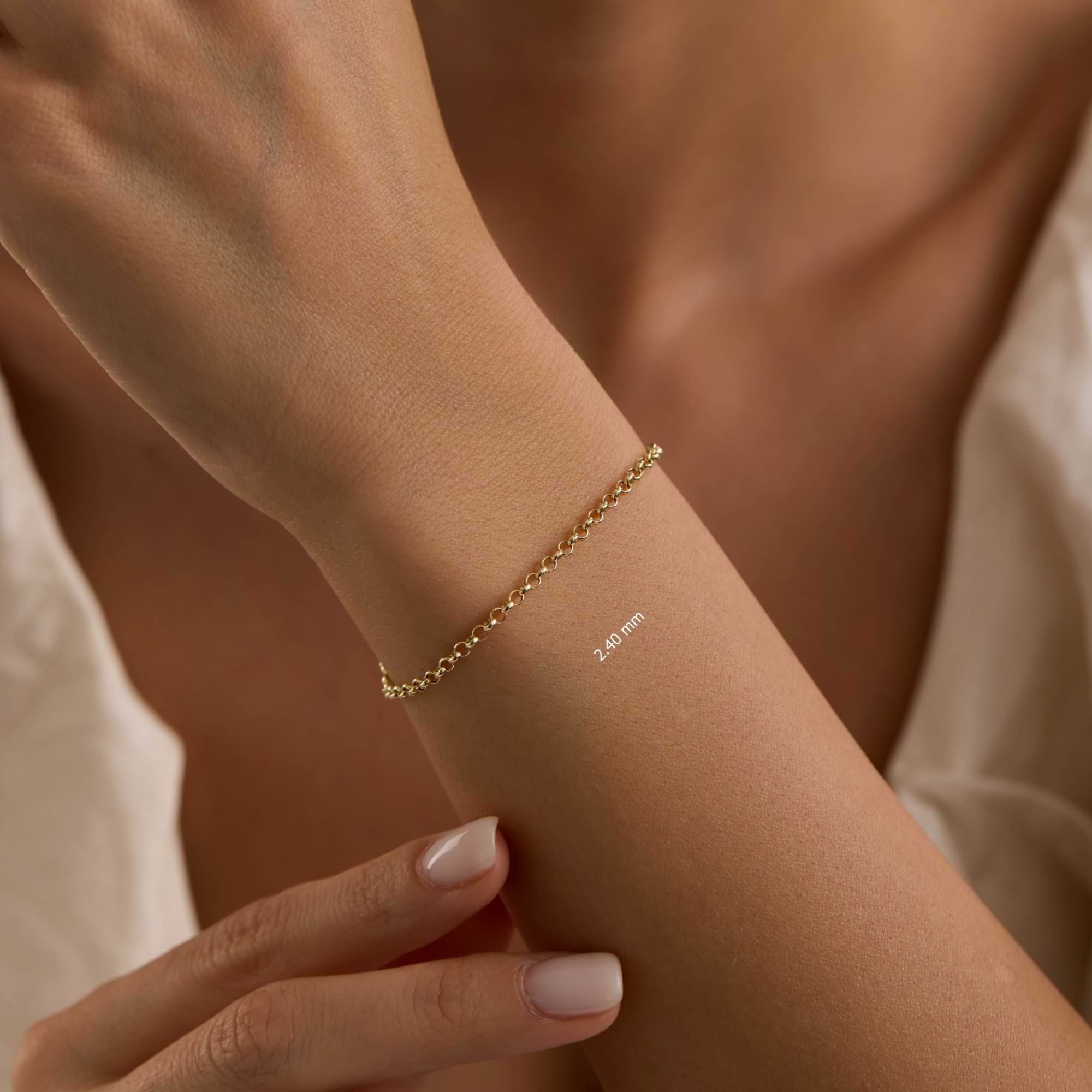 Gold rolo 2.4mm chain bracelet on a wrist with a neutral background