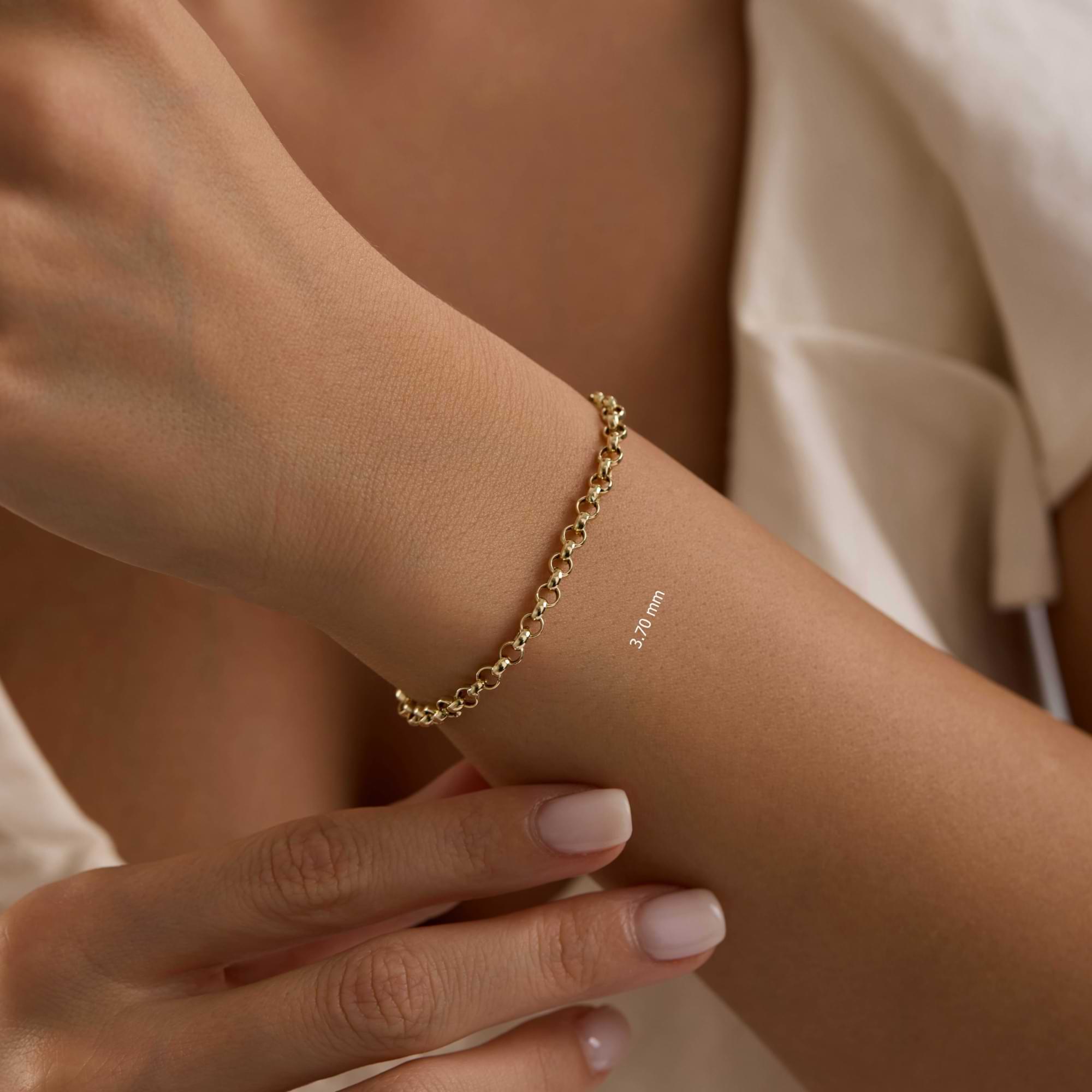 Gold rolo chain 3.7mm bracelet on a wrist with a neutral background